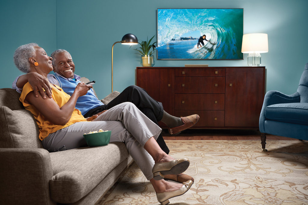 old african american couple watching tv at home